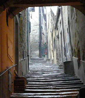 Every tiny Tuscan town is as beautiful as the last. We’d wind up the narrow roads among the rows of barren grapevines and lively march of gray-leaved olive trees. At the top, we’d park and climb a maze of narrow cobbled streets that meandered up to a main piazza and church where tunnel-like alleys dropped away, revealing slivers of the landscape. It might be a toss up as to whether I liked Cortona or Montalcino better. Both are very sweet southern Tuscan hill towns with equally charming characteristics. The unique clock tower in Cortona towers over an intimate little piazza. Narrow streets lead out from the piazza with stores full of leather goods, fine stationary and books, and pastries lining both sides.